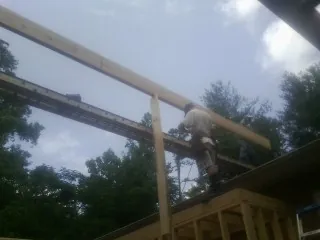 Carpenter setting a ridge beam over a new addition frame — Ice Dam Removal by Roofing Brothers in Moultonborough