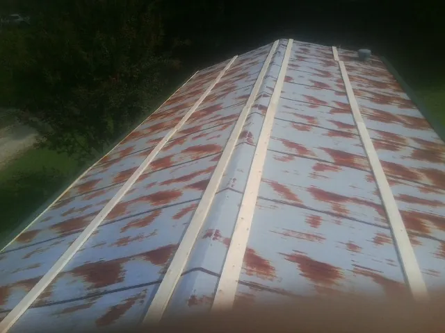 Rusted metal roof panels with new wood purlins before replacement — Storm Damage Roof Repair in Moultonborough by Roofing Brothers